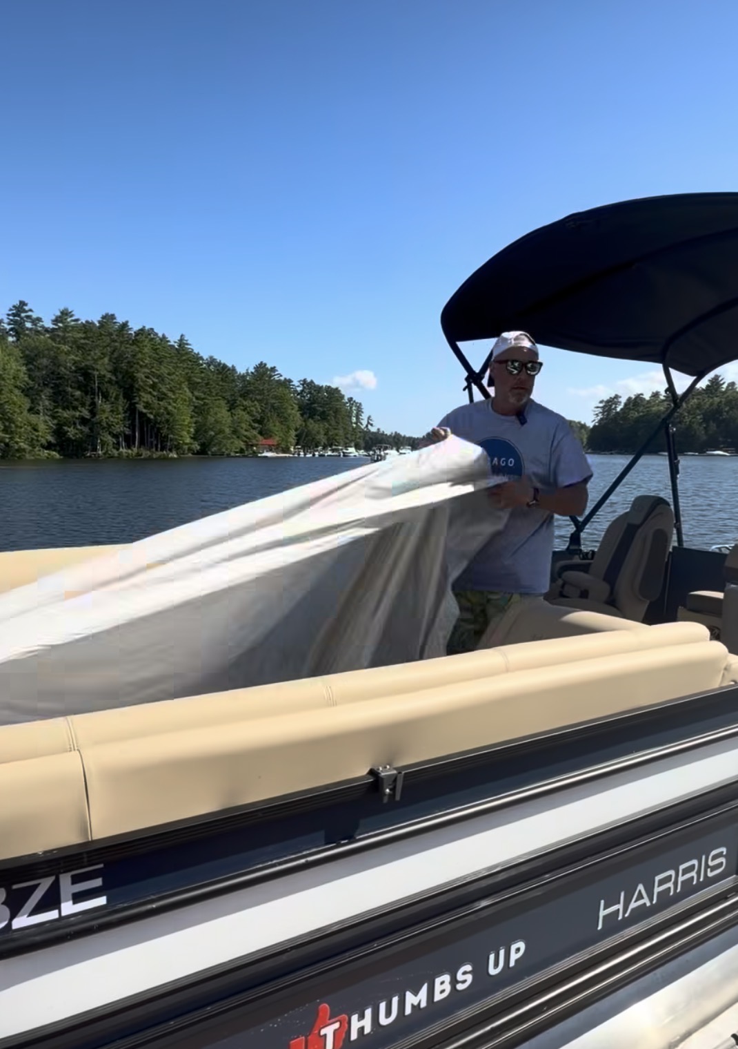 Boater lifting the lightweight Quick Boat Cover from pontoon seats